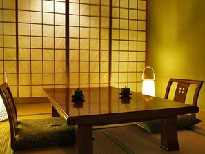 A traditional Japanese room with tatami flooring, a low wooden table, and a sliding door with a grid pattern. - Atami Morino Onsen Hotel (Atami)