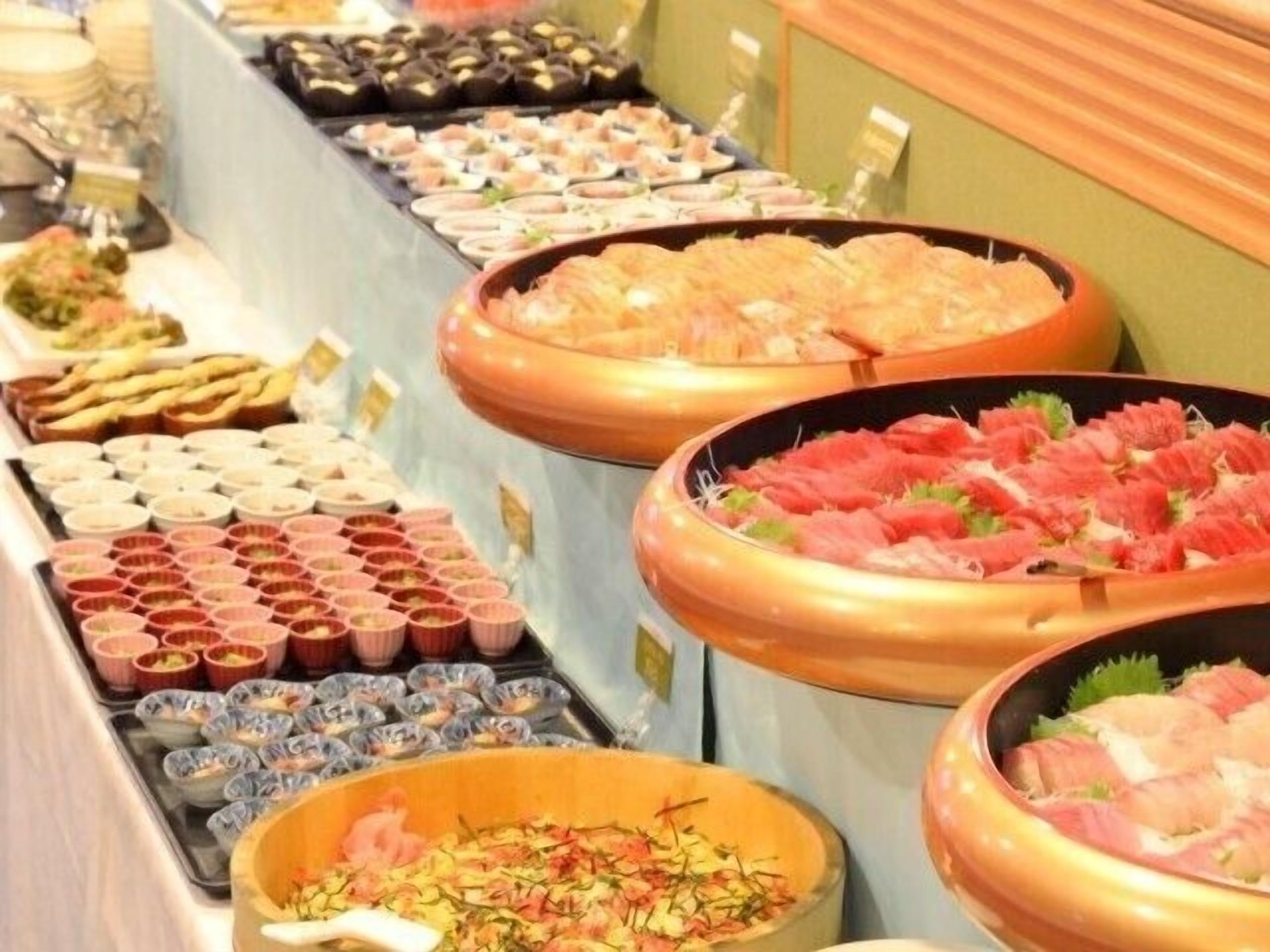 Un bufé con diversas opciones de comida, incluyendo mariscos y aperitivos.
