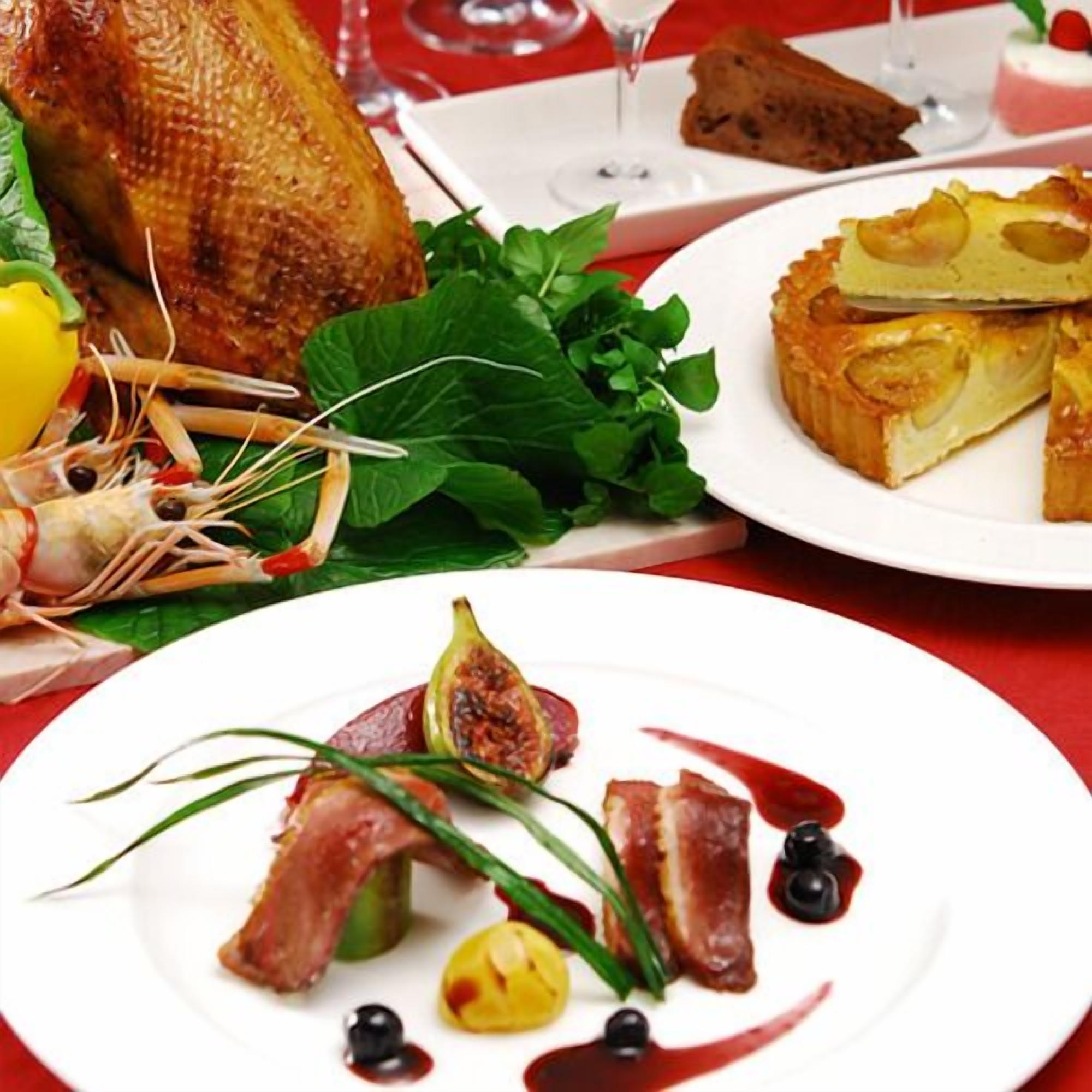 A dining table with a variety of dishes, including seafood, vegetables, and a dessert.