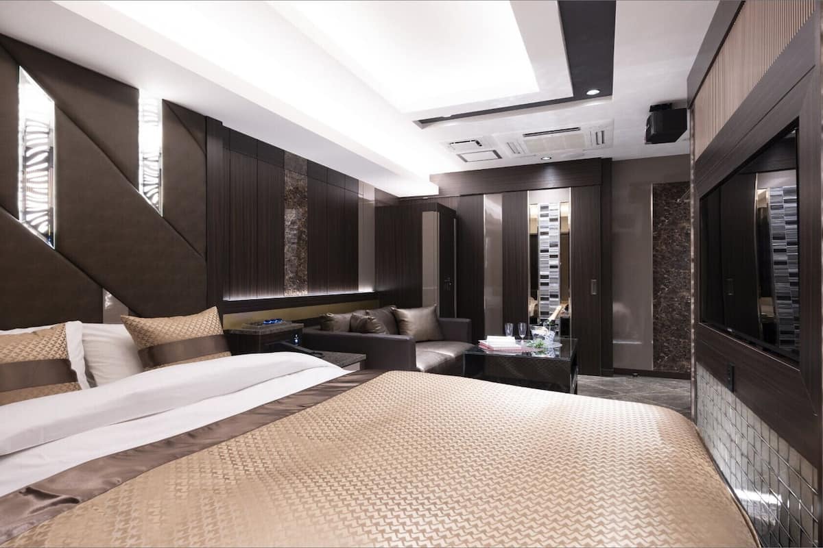Une chambre d’hôtel moderne dotée d’un grand lit, d’un coin salon et d’une armoire.
