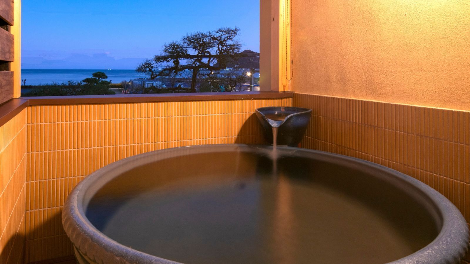 Thermalbad mit Blick auf das Meer und Bäume.