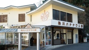 A building with a sign reading 'Atagawa Tropical & Alligator Garden' and another sign for 'Hot River Banana Garden'. - Atami Onsen Umibe no Yado Nagahamaen (Atami)