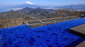 A rooftop pool with a view of a mountain and a cityscape. - Atami Onsen Umibe no Yado Nagahamaen (Atami)