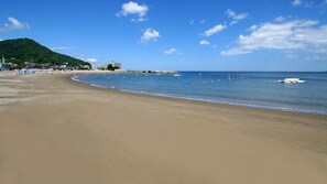 A wide sandy beach with a clear blue sky and a few boats in the water. - Atami Onsen Umibe no Yado Nagahamaen (Atami)