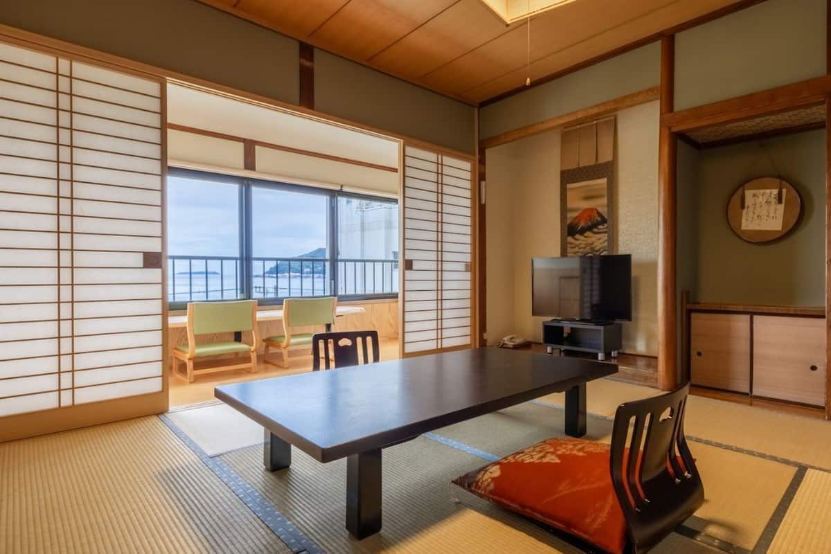 Ein traditioneller japanischer Raum mit Tatami-Böden, einem niedrigen Tisch und Schiebetüren.
