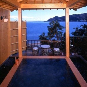 A wooden pergola with a view of the sea and mountains.