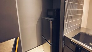 Una cocina compacta con microondas, refrigerador y horno integrado.