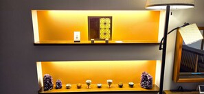Ein Zimmer mit einer Ablage, die Dekorationsgegenstände und eine Lampe zeigt.