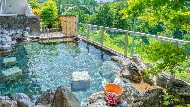 Una piscina cristalina rodeada de rocas y un banco de madera.