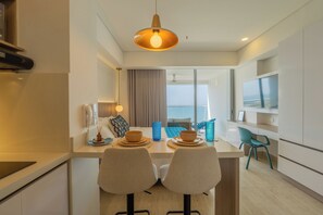 Eine moderne Küche mit Essbereich, einem großen Fenster und Meerblick.