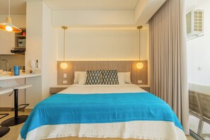 Ein modernes Hotelzimmer mit Bett, Nachttischlampen, einem Schreibtisch und einem Fenster mit Vorhängen.