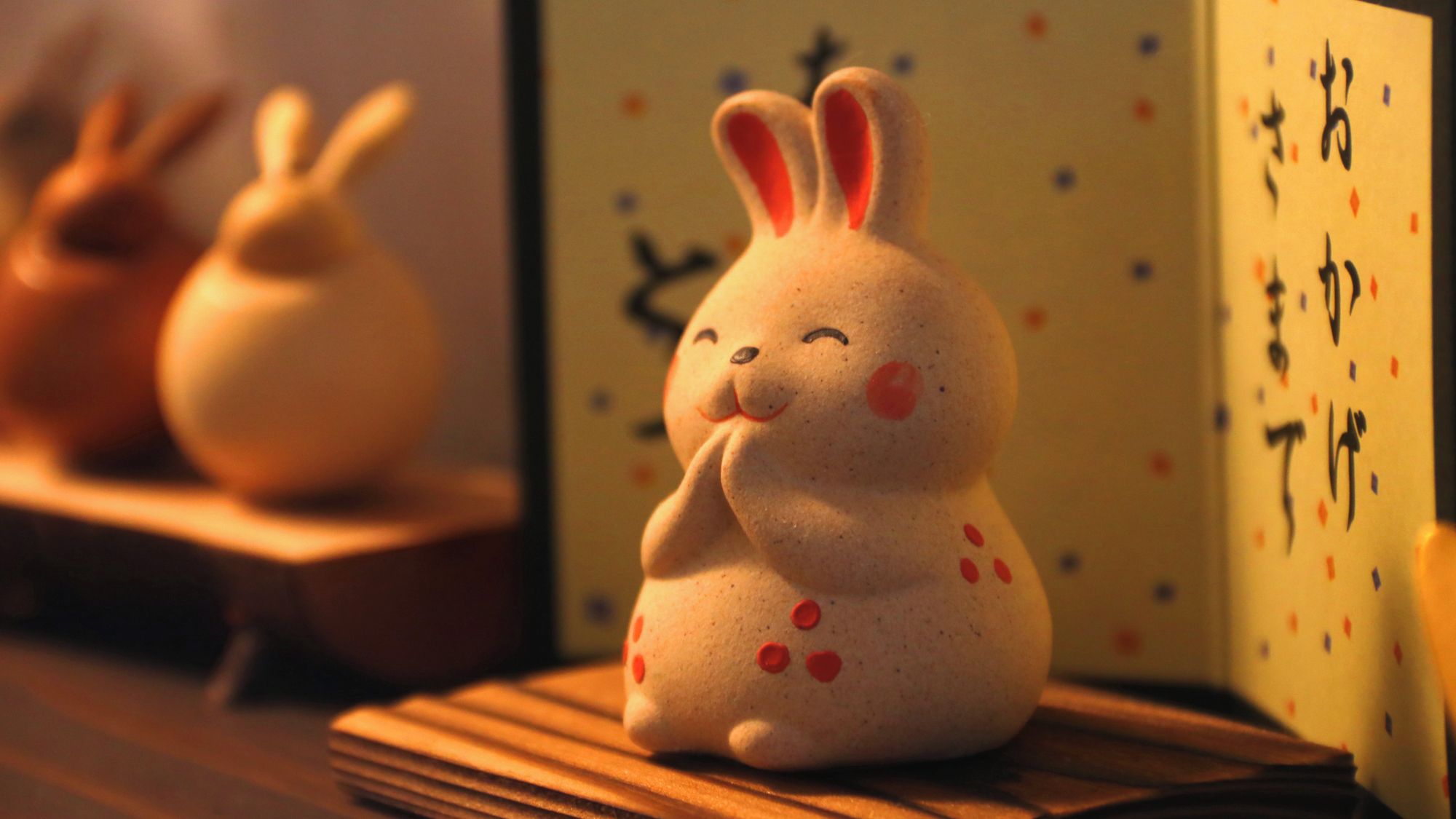 A ceramic rabbit figurine on a wooden surface.