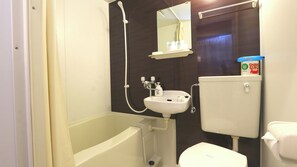 Un baño con bañera, lavamanos, inodoro y espejo.