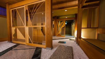 A traditional Japanese interior with wooden sliding doors, a carpeted floor, and a staircase.