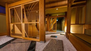 A traditional Japanese interior with wooden sliding doors, a carpeted floor, and a staircase. - Wakamatsu Ryokan (Hakodate)