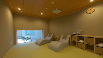 A room with tatami flooring, a water dispenser, and a view of a snowy landscape.