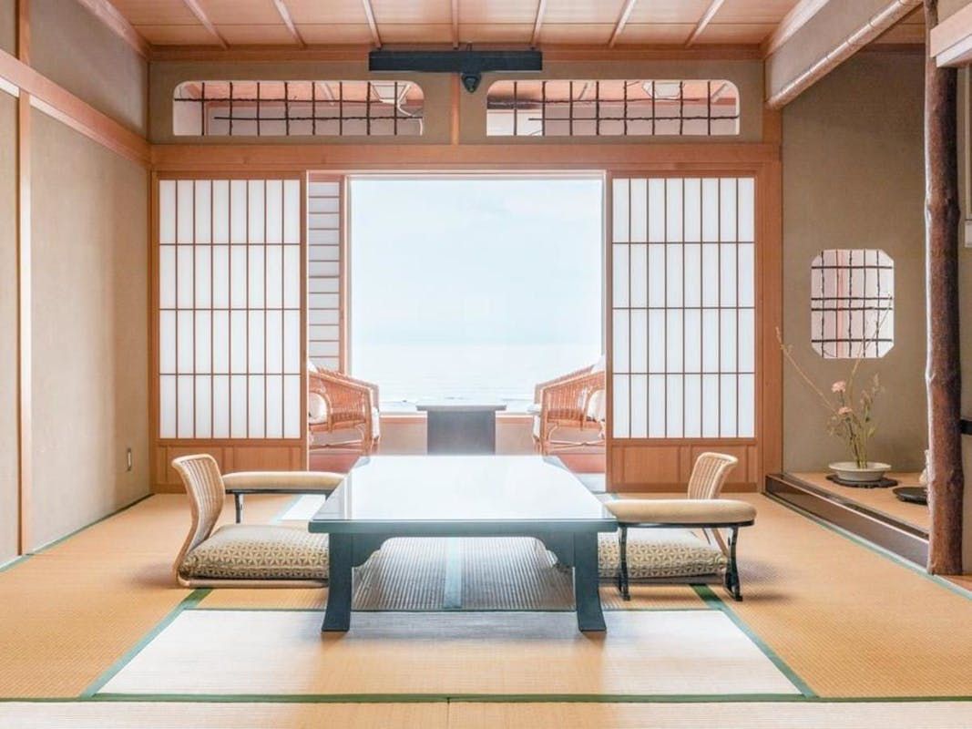 A traditional Japanese room with tatami flooring, a low table, and sliding doors.