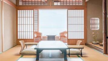 A traditional Japanese room with tatami flooring, a low table, and sliding doors.