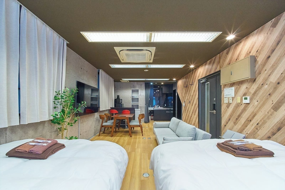 Une chambre d’hôtel moderne équipée de deux lits, d’un coin repas et d’une kitchenette.