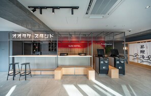 A reception desk with a check-in/out counter, a seating area, and a small bar area with stools.