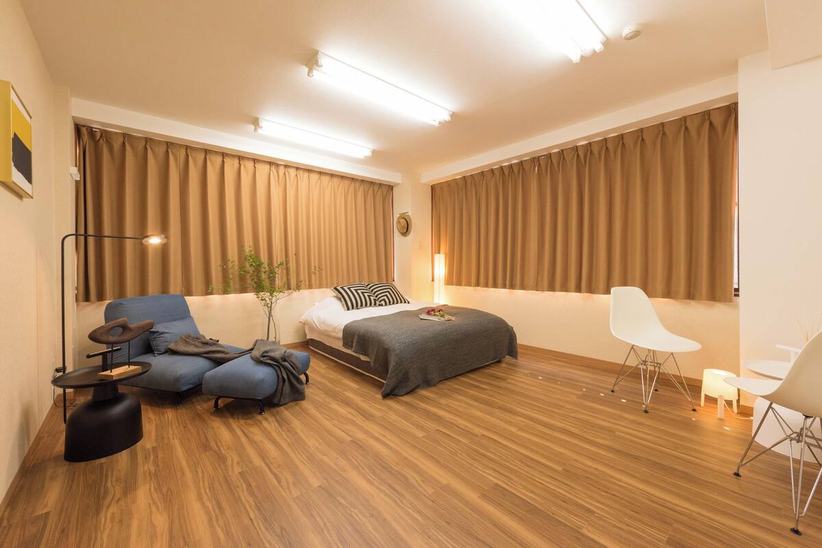 Ein modernes Hotelzimmer mit Sofa, Bett, Schreibtisch und Stuhl.