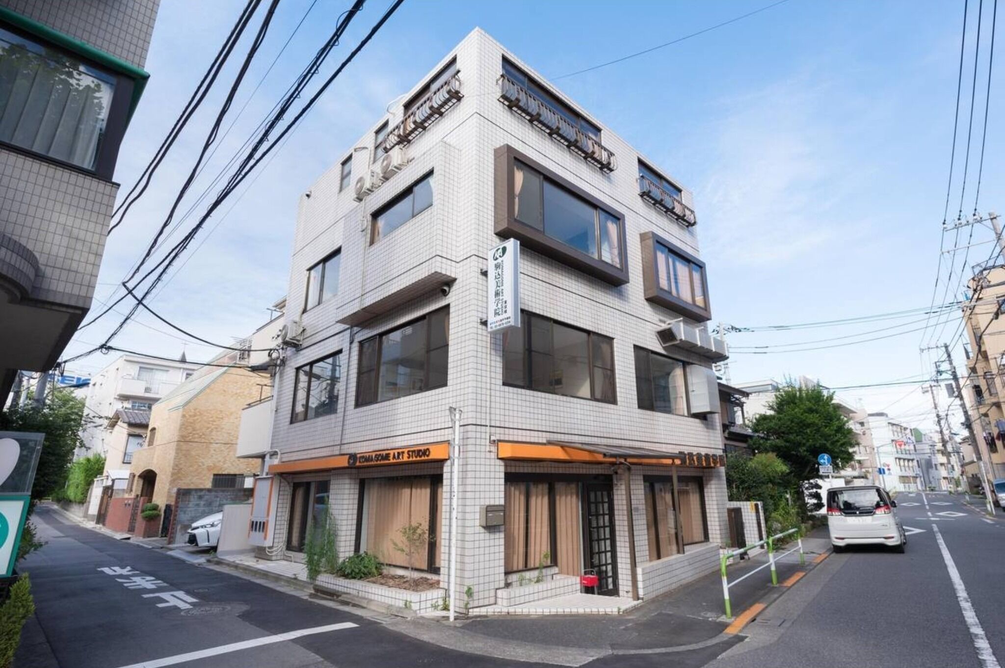 A multi-story building with a commercial ground floor featuring a sign for a business.