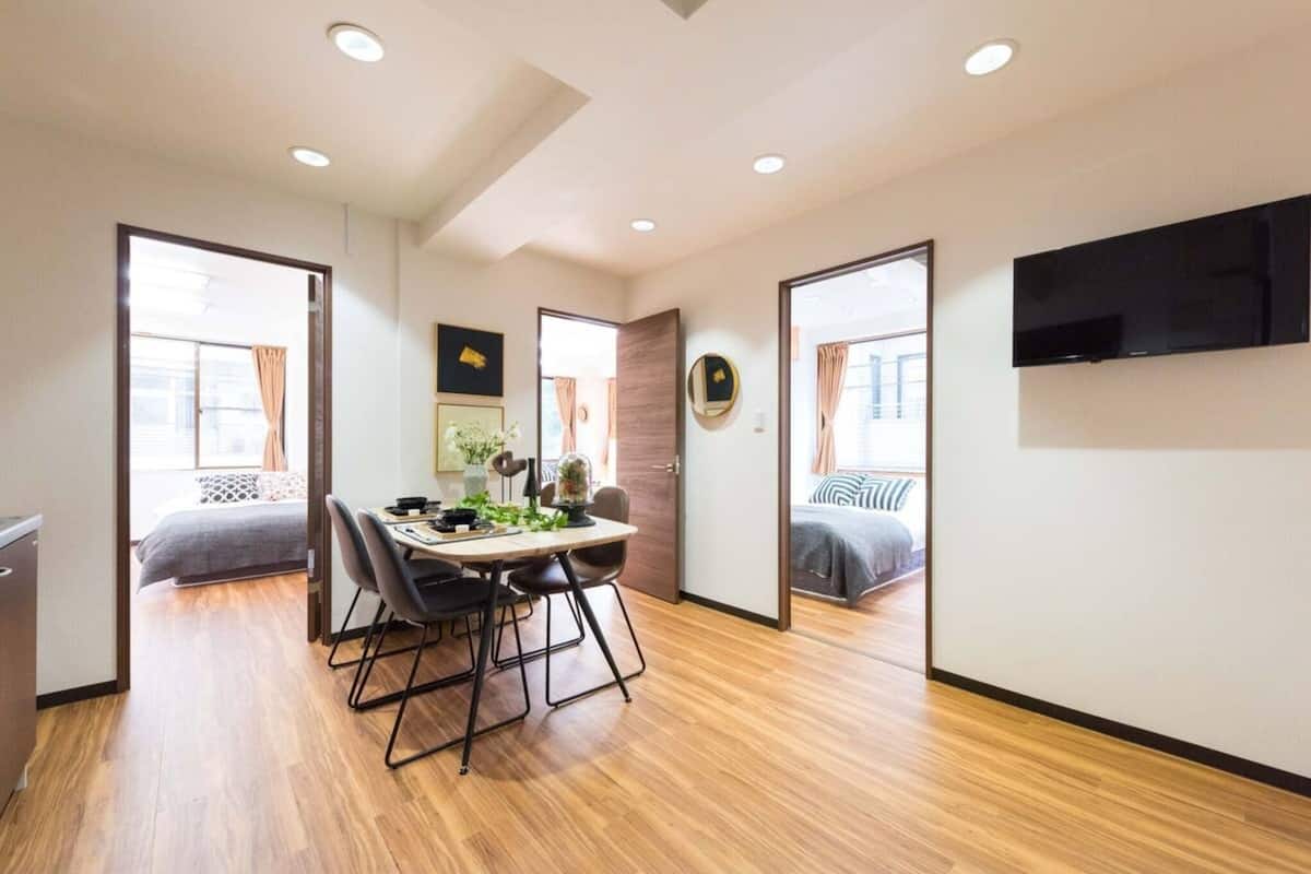 Eine moderne Wohnung mit Essbereich, einem an der Wand montierten Fernseher und einem Bett mit Blick.