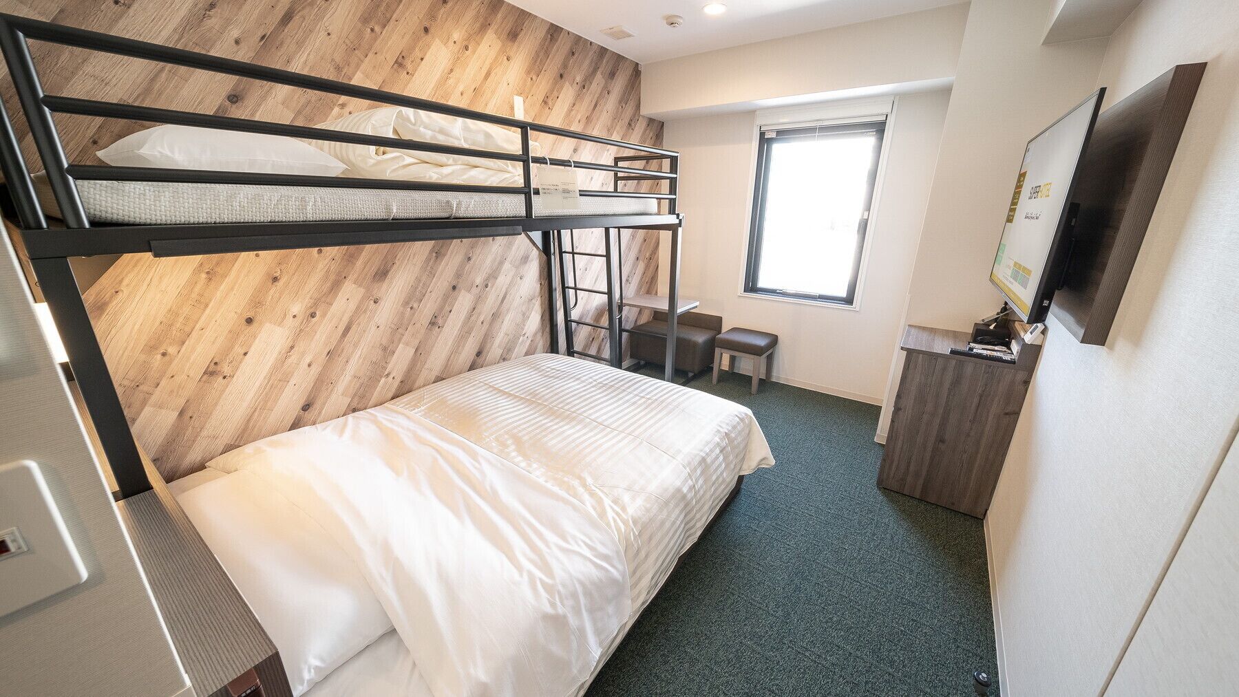 Une chambre avec un lit superposé, un bureau et une fenêtre.