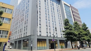 Un hôtel à plusieurs étages doté d’une façade moderne, de grandes fenêtres et d’une entrée bien visible avec une enseigne.