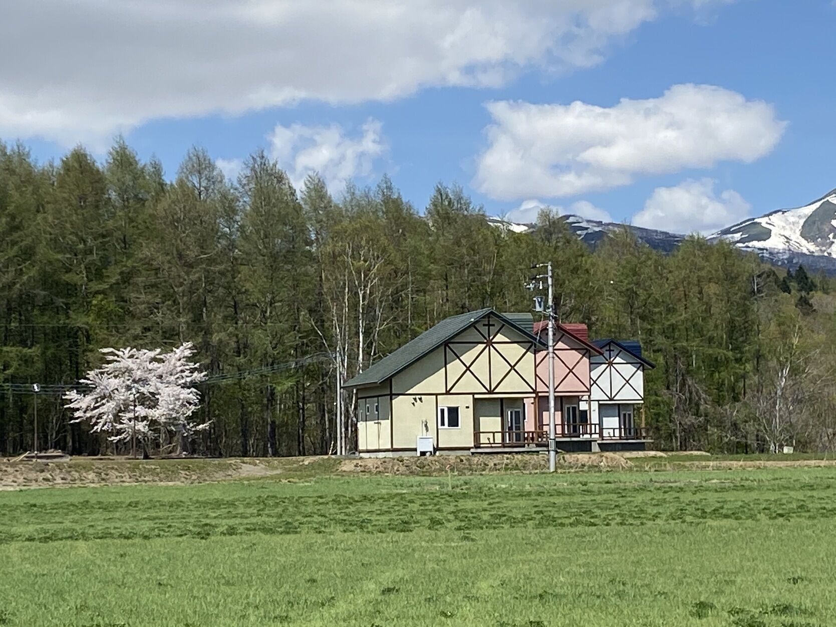 Ein Haus mit Satteldach, Schornstein und einer kleinen Veranda.