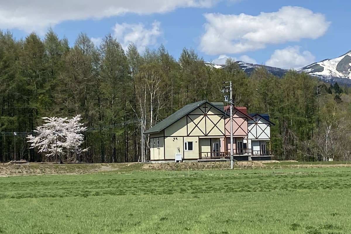 A house with a gabled roof, a chimney, and a small porch.