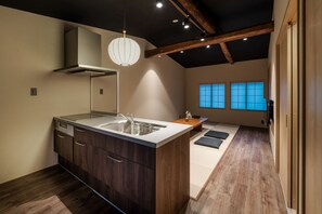 A modern kitchen with a central island, wooden cabinets, and a built-in stove. - Yamagoya Kiccho (Matsue)