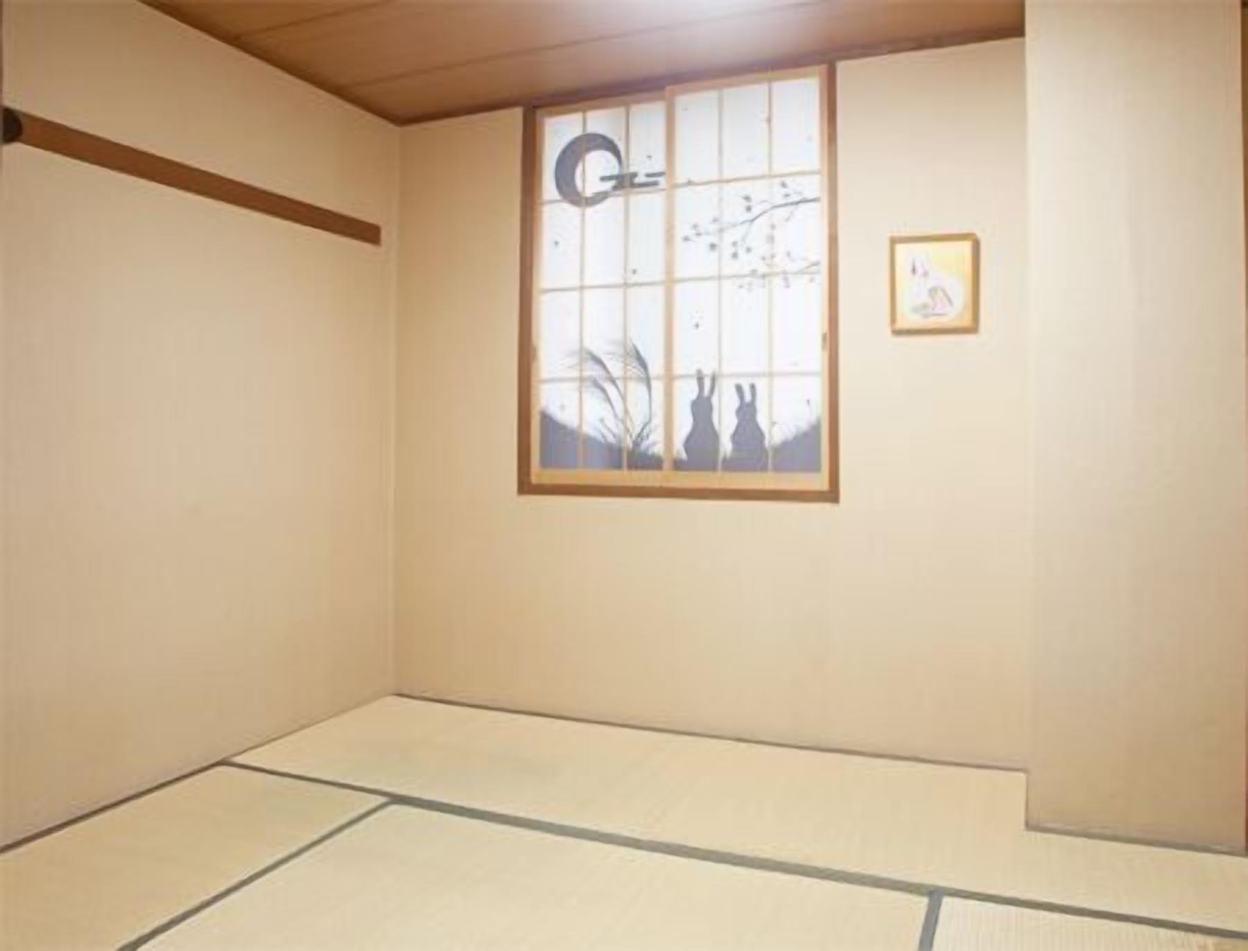 A room with tatami flooring, a shoji screen window, and a framed picture on the wall.
