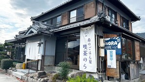 A traditional Japanese building with a sign for 'NORA' and another sign indicating a restaurant. - Nora (Hokuto)
