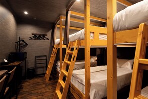 Ein Zimmer mit Etagenbetten, einem Schreibtisch und einem Stuhl.