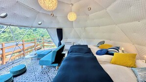 A tent-style room with a bed, seating area, and a view of the outdoors. - Nora (Hokuto)