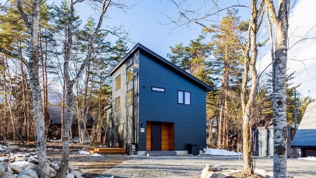 A modern two-story building with a dark exterior, surrounded by trees and a gravel driveway. - Spa & Hotel La Fontaine Suwa (Ueda)
