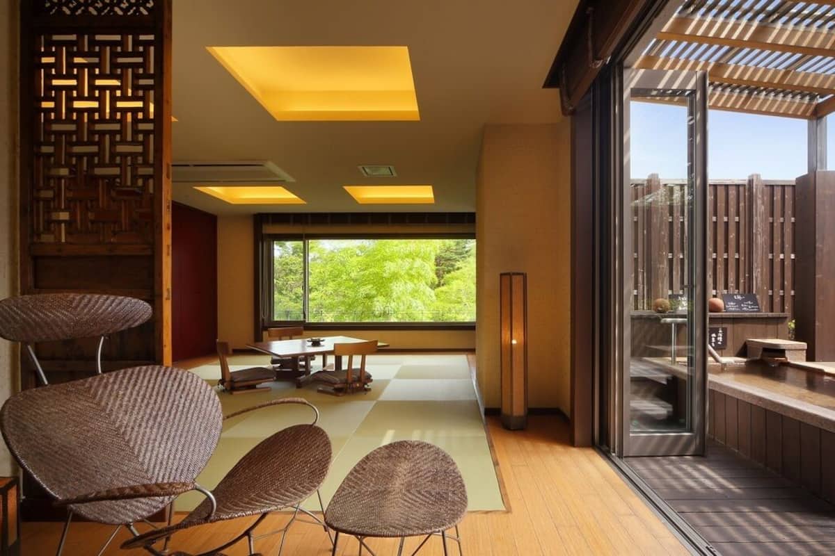 Un interior moderno con comedor, ventanas amplias y vistas a la vegetación.