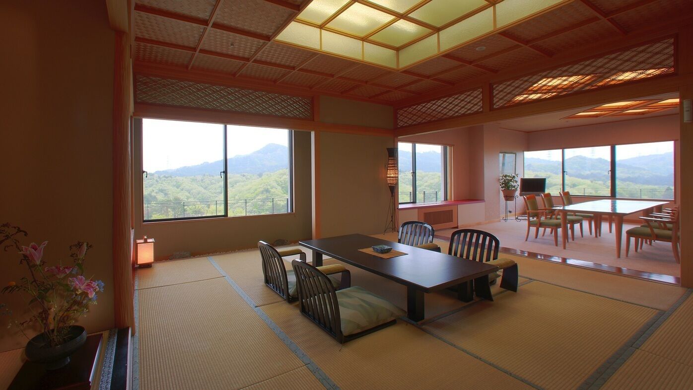 A traditional Japanese-style room with tatami flooring, a low table, and chairs.
