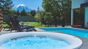 A hot tub with a view of a mountain, outdoor furniture, and a swimming pool. - Orando no Nikai (Aridagawa)