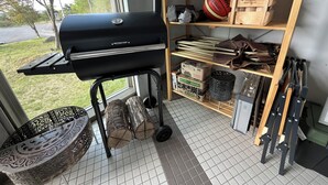 A kitchen with a grill, a shelf with various items, and a view of the outdoors. - Orando no Nikai (Aridagawa)