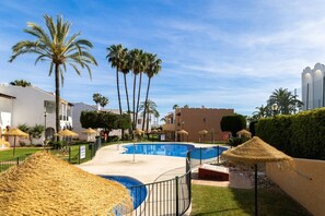 A resort with multiple swimming pools, palm trees, and thatched umbrellas. - Apartment Rio Marinas - 1 bedroom - by the beach (Nerja)