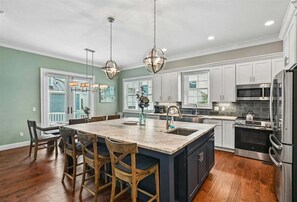 A kitchen with a large island, stainless steel appliances, and pendant lighting. - Impressive Game Room, Pool, Steps to Beach, Great Location, Free Golf (Hilton Head Island)
