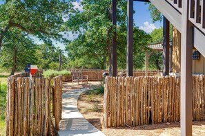 Une clôture en bois, un chemin et un bâtiment doté d’une zone abritée.