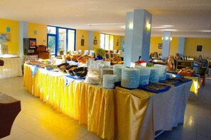 Uma mesa de buffet com várias estações de comida e uma grande variedade de pratos.
