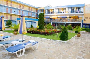 A hotel courtyard with lounge chairs, umbrellas, and a pool area. - Hotel Azurro (Nessebar)