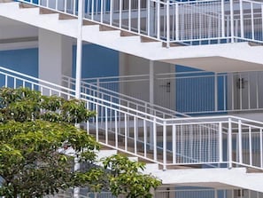 Un edifici de diverses plantes amb baranes i balcons blancs, de disseny arquitectònic modern.