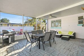 An outdoor patio with a grill, dining table, chairs, and a sofa. - SALTAIRE RETREAT ST PETE  (St. Petersburg)