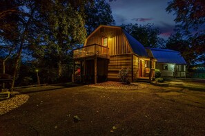 Eine Holzhütte mit Veranda, umgeben von Bäumen.