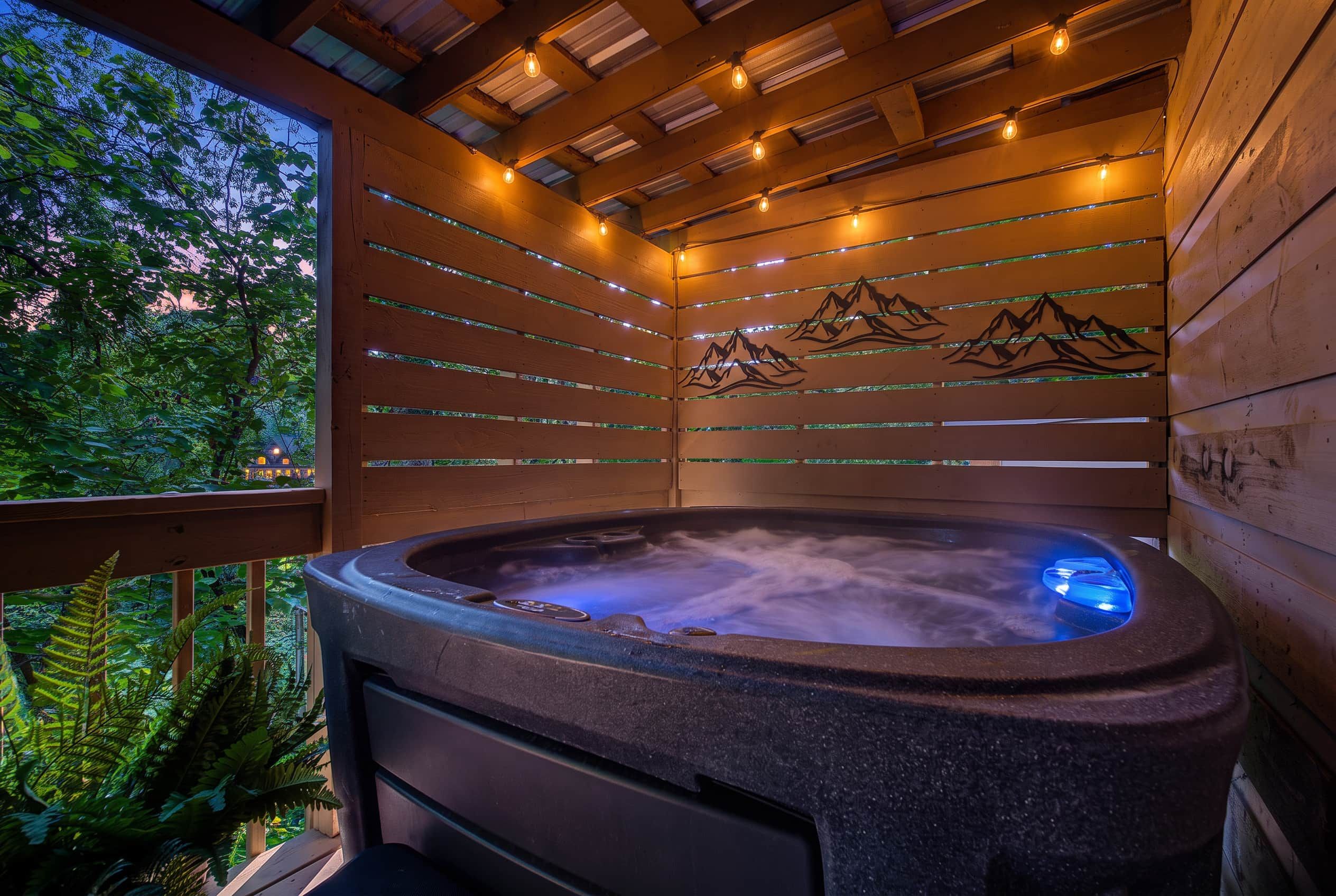 A hot tub with a wooden exterior and a view of mountains through the glass panels.